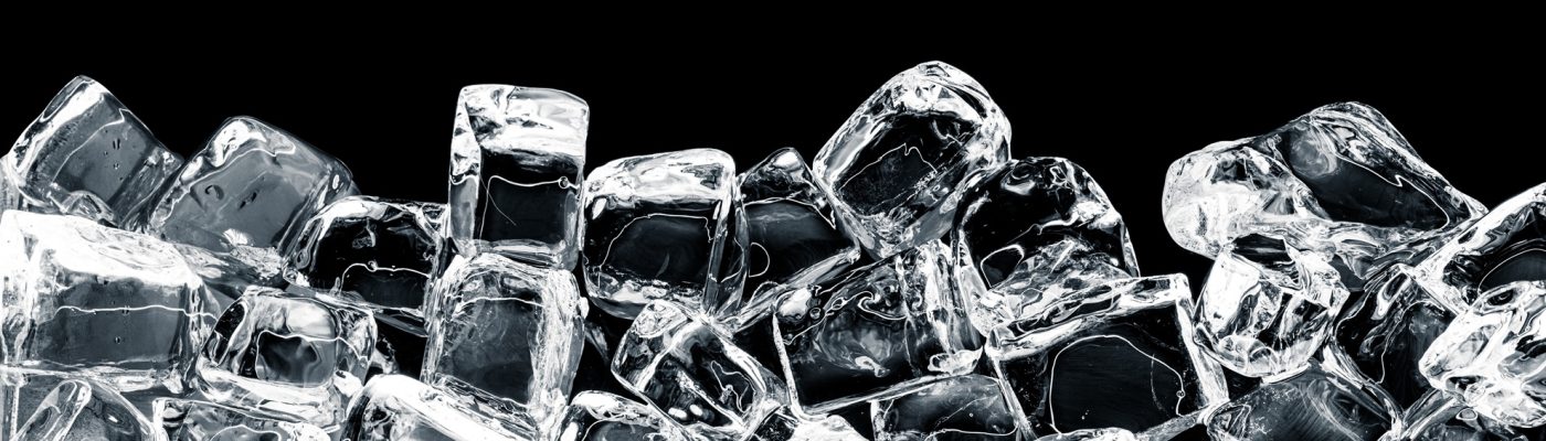 Crystal-clear ice cube on a dark surface